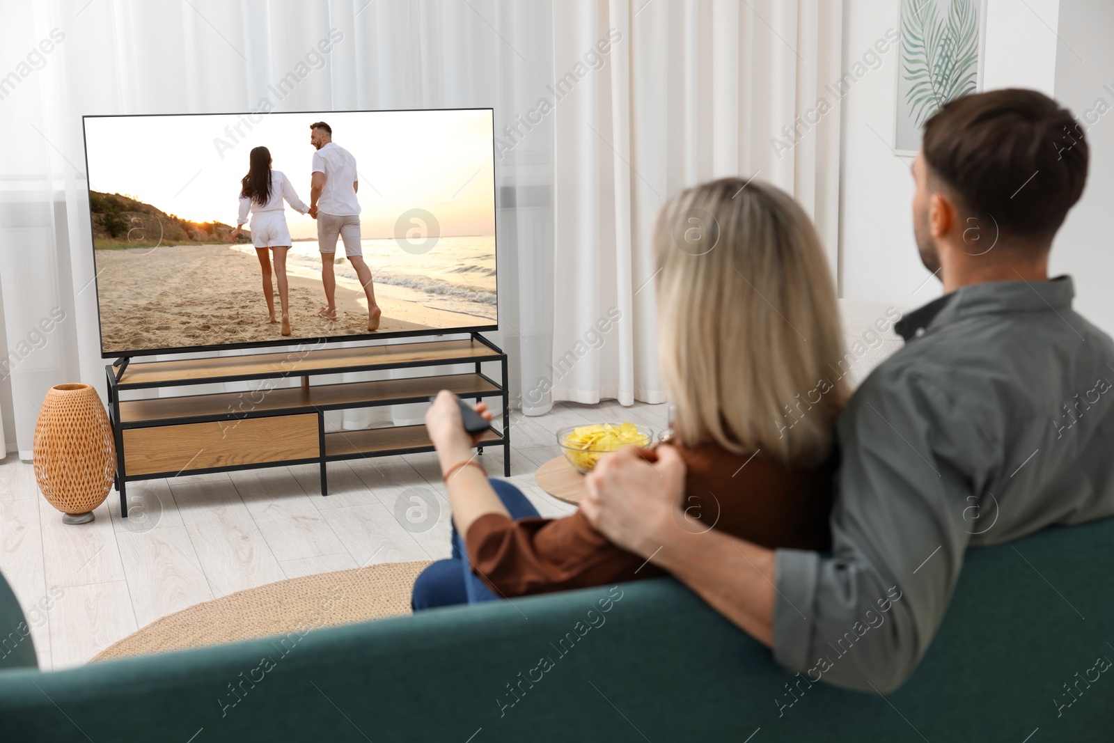 Image of Couple watching movie on TV set at home