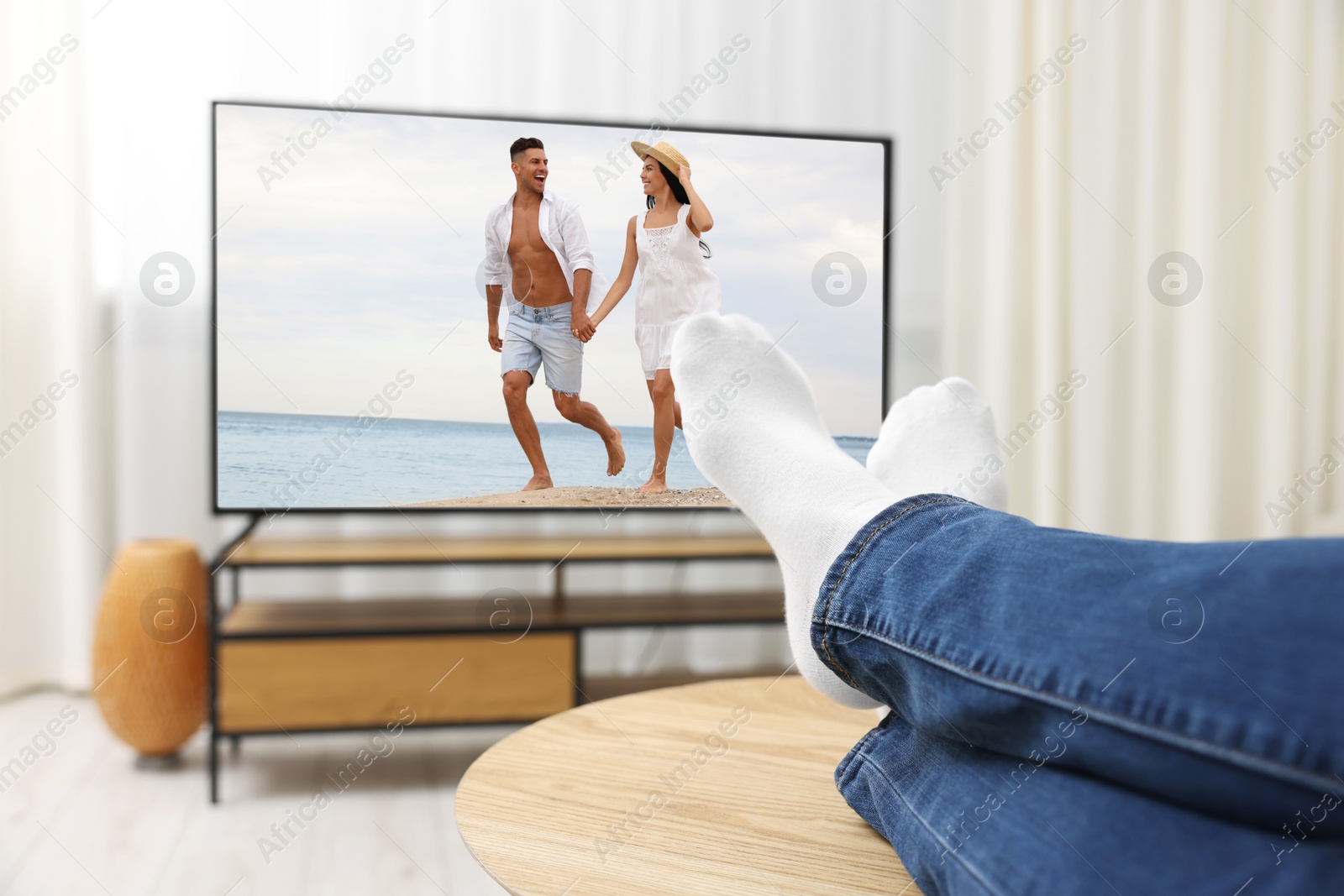 Image of Man watching movie on TV set at home