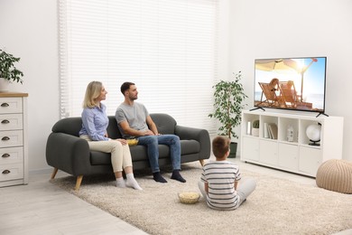 Image of Family watching movie on TV set at home