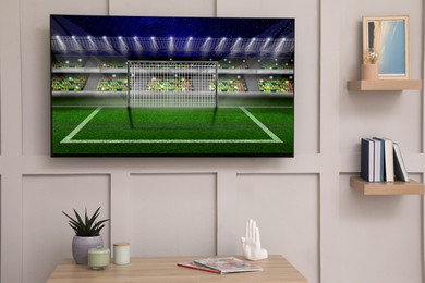 Image of Soccer game playing on TV set in room