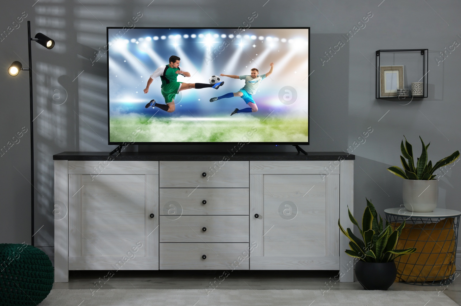 Image of Soccer game playing on TV set in room