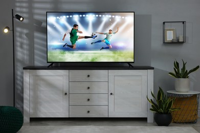 Image of Soccer game playing on TV set in room