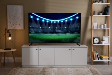 Image of Sport game playing on TV set in room