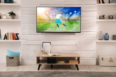 Image of Soccer game playing on TV set in room