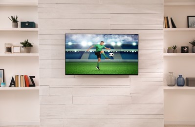 Image of Soccer game playing on TV set in room