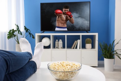 Image of Man watching boxing fight on TV set at home, closeup