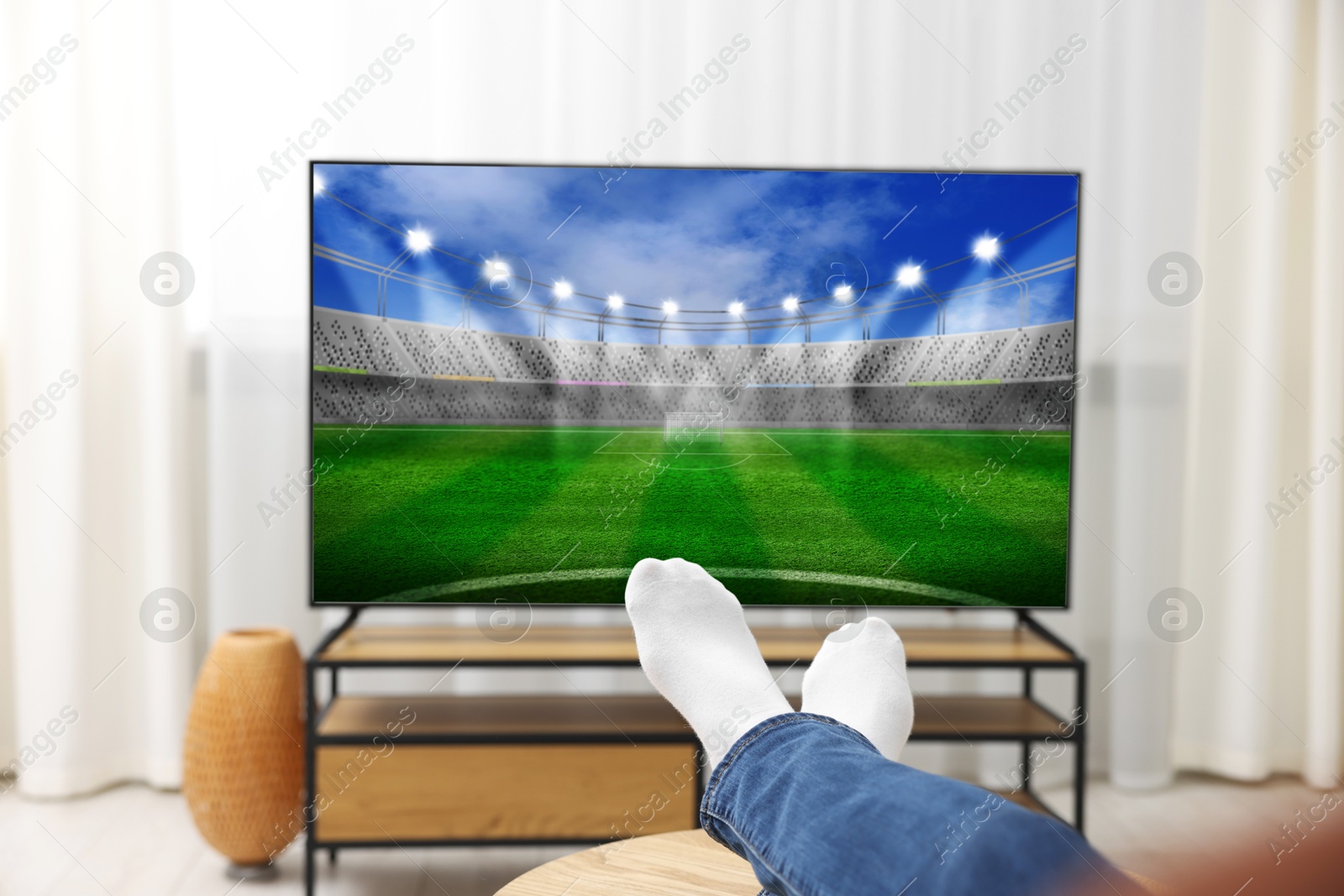 Image of Man watching sport game on TV set at home, closeup