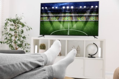 Image of Man watching sport game on TV set at home, closeup