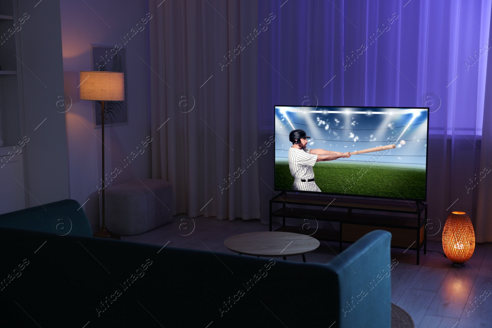 Image of Baseball game playing on TV set in room at night