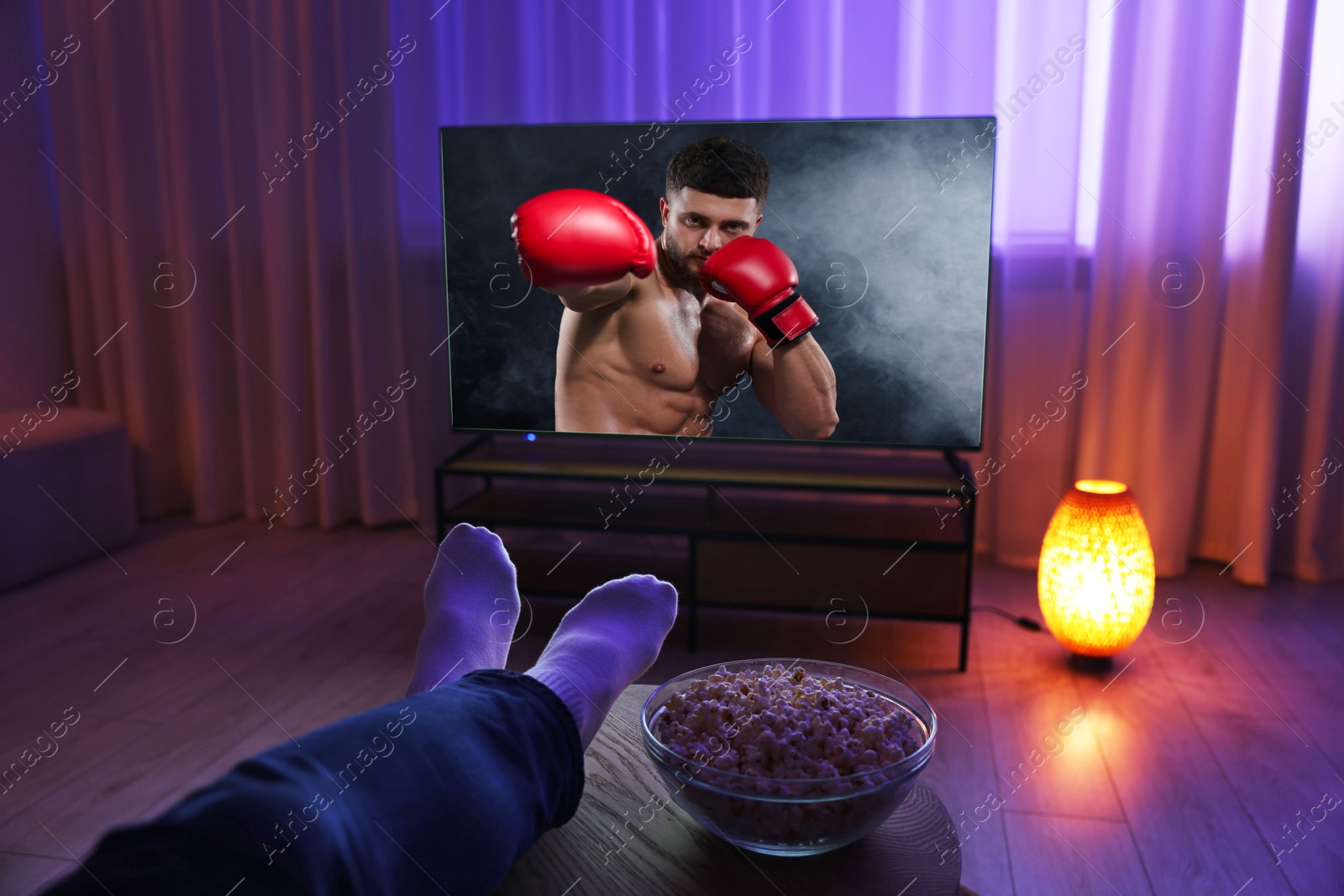 Image of Man watching boxing fight on TV set at home, closeup