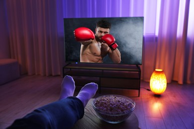 Image of Man watching boxing fight on TV set at home, closeup