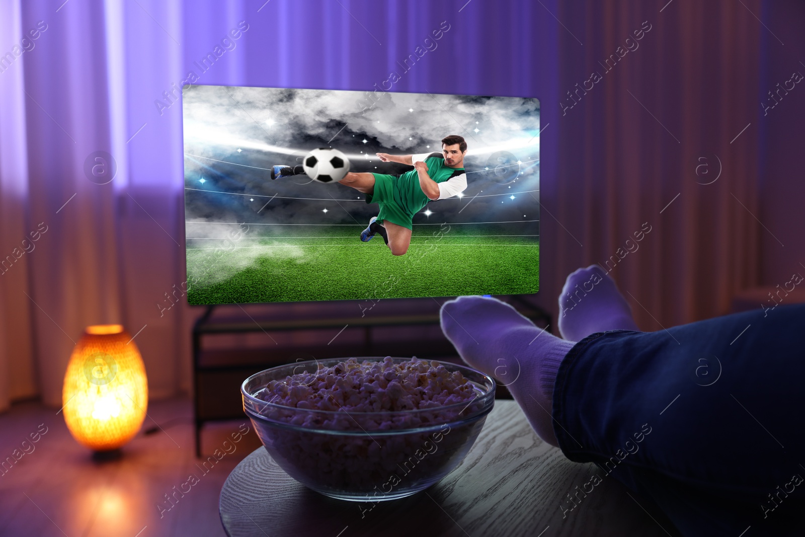 Image of Man watching soccer game on TV set at home, closeup