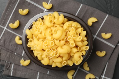 Photo of Raw horns pasta in bowl on table, top view