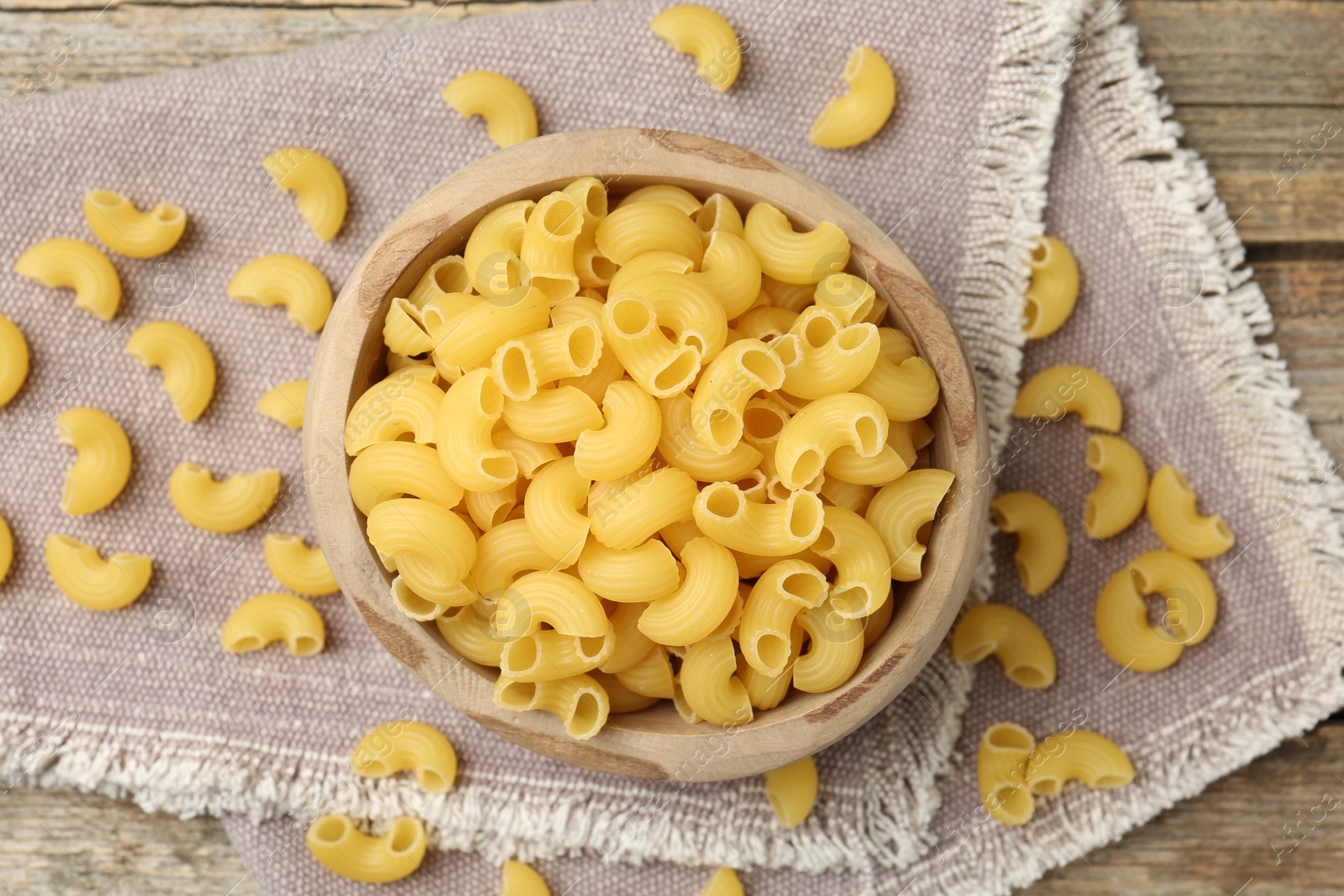 Photo of Raw horns pasta in bowl on table, top view