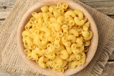 Photo of Raw horns pasta in bowl on table, top view