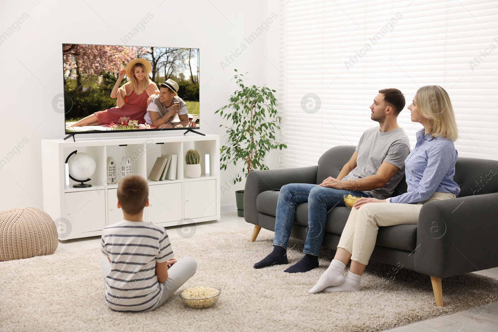 Image of Family watching movie on TV set at home