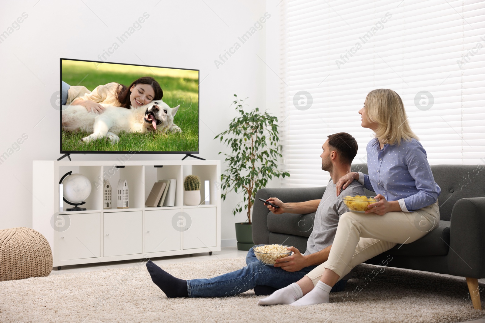 Image of Couple watching movie on TV set at home