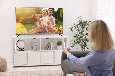 Image of Woman watching movie on TV set at home