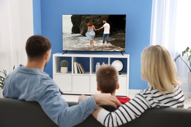 Image of Family watching movie on TV set at home