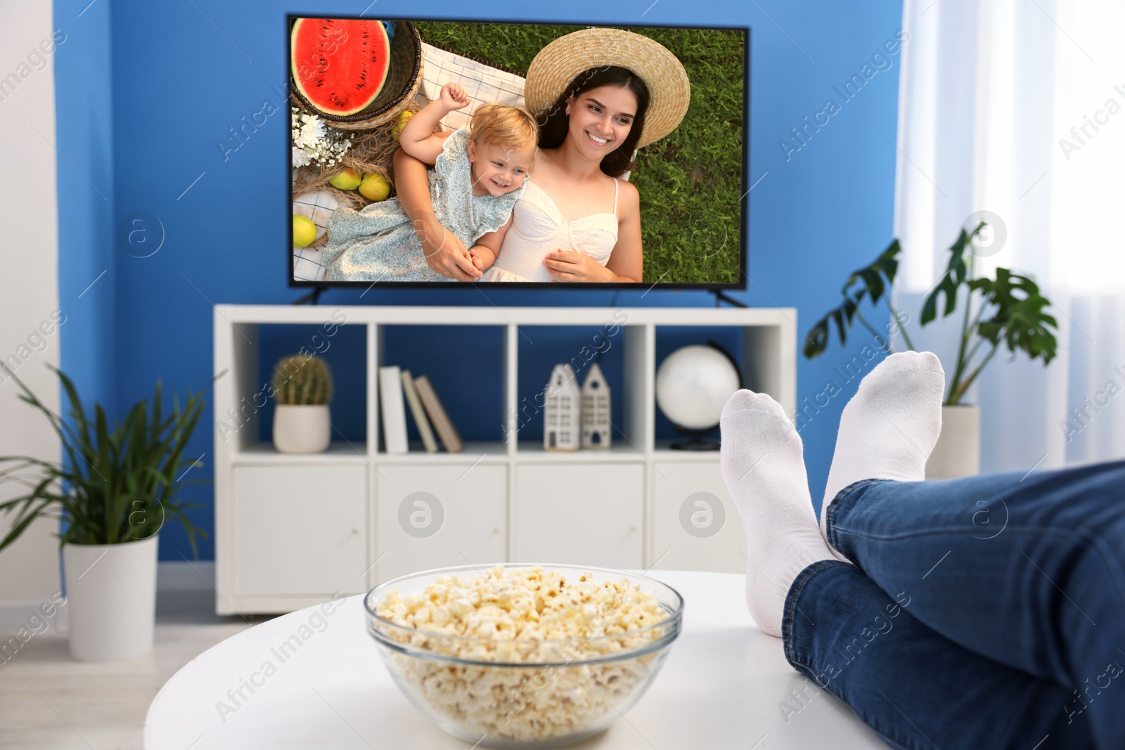 Image of Man watching movie on TV set at home