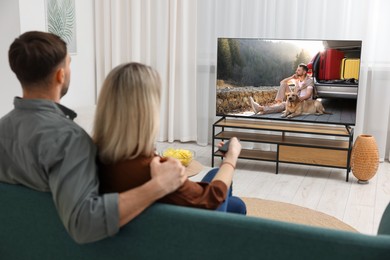 Image of Couple watching movie on TV set at home