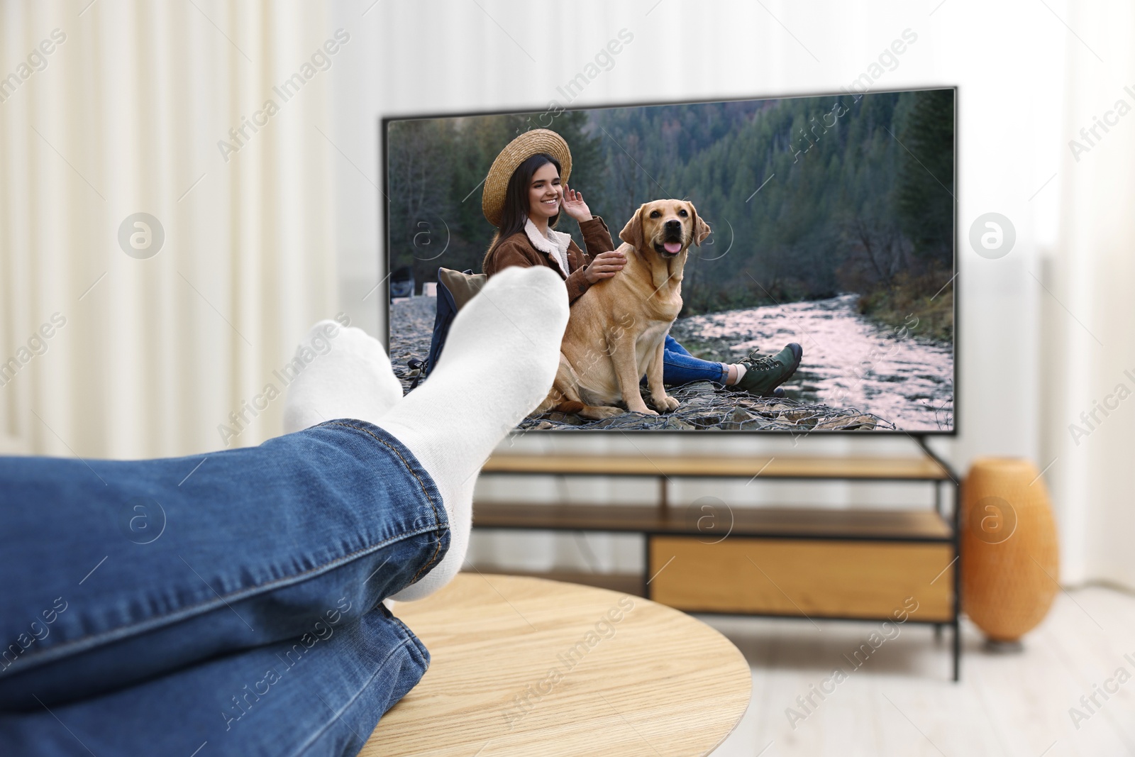 Image of Man watching movie on TV set at home