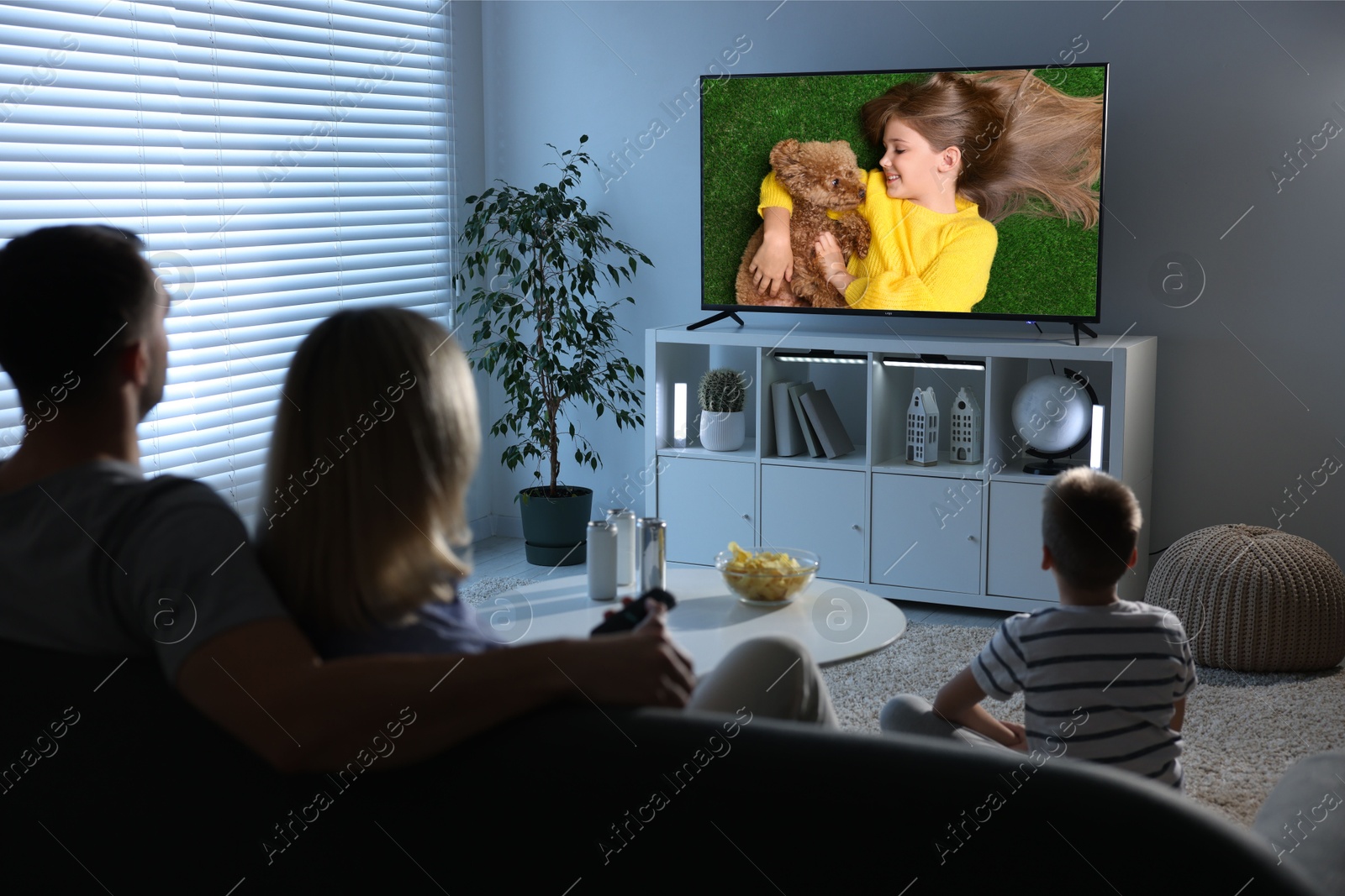 Image of Family watching movie on TV set at home