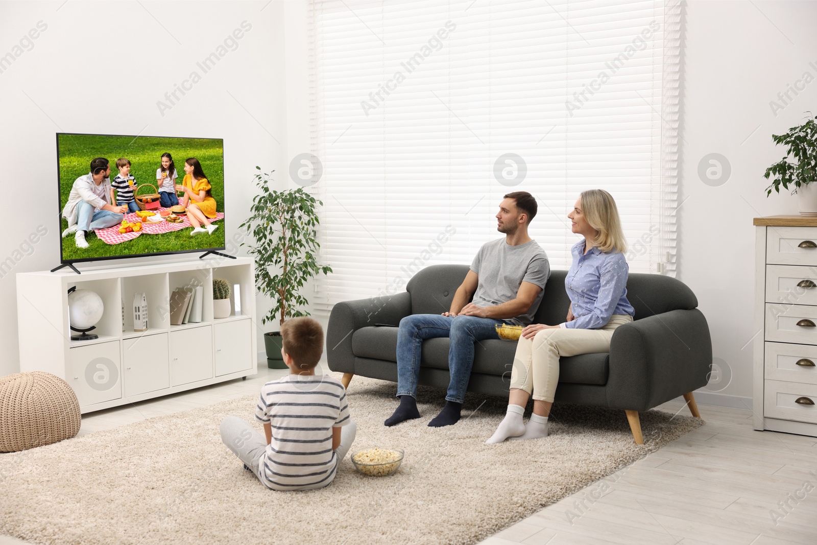 Image of Family watching movie on TV set at home