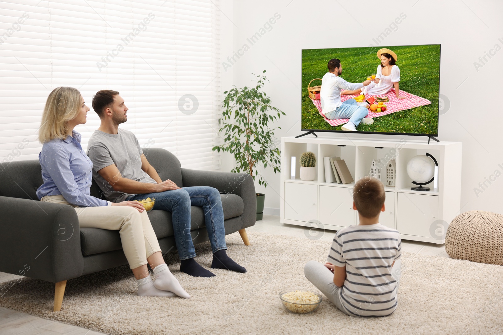 Image of Family watching movie on TV set at home