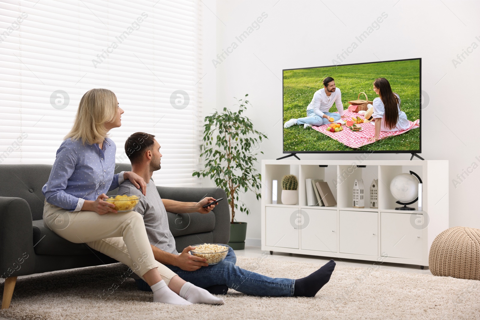 Image of Couple watching movie on TV set at home