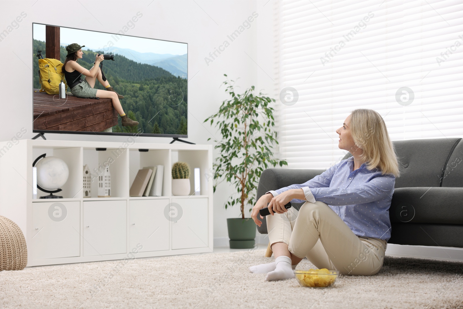 Image of Woman watching movie on TV set at home