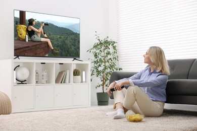 Image of Woman watching movie on TV set at home