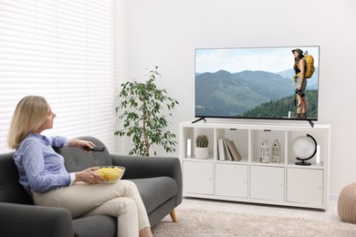 Image of Woman watching movie on TV set at home