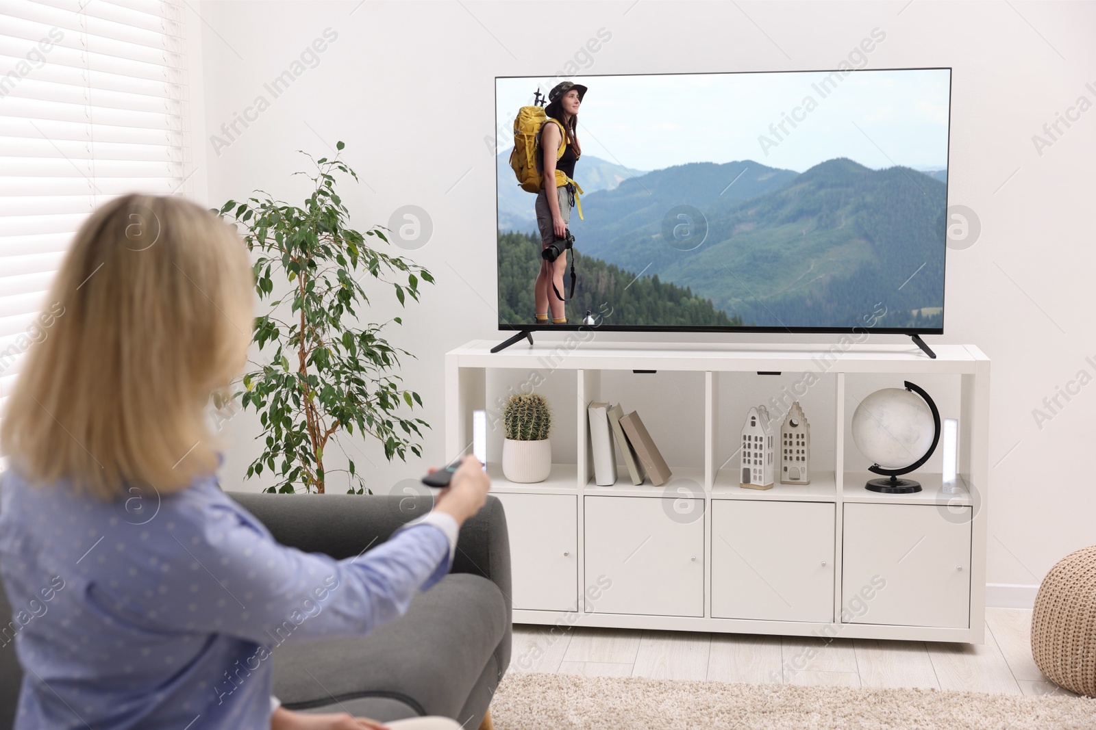 Image of Woman watching movie on TV set at home