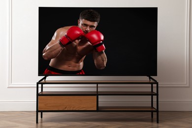 Image of Boxing fight playing on TV set in room