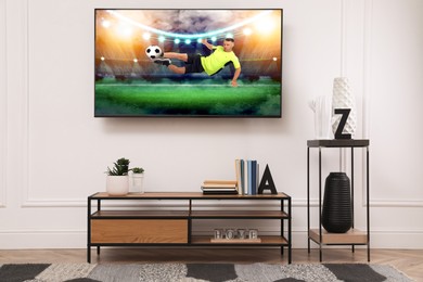 Image of Soccer game playing on TV set in room