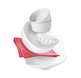 Image of Clean dishware and red checkered napkin flying on white background