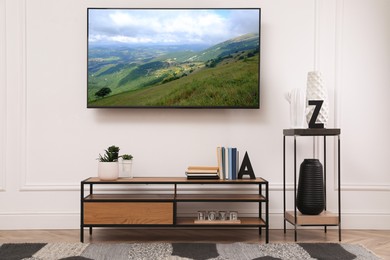 Image of TV set with mountain landscape on screen in room