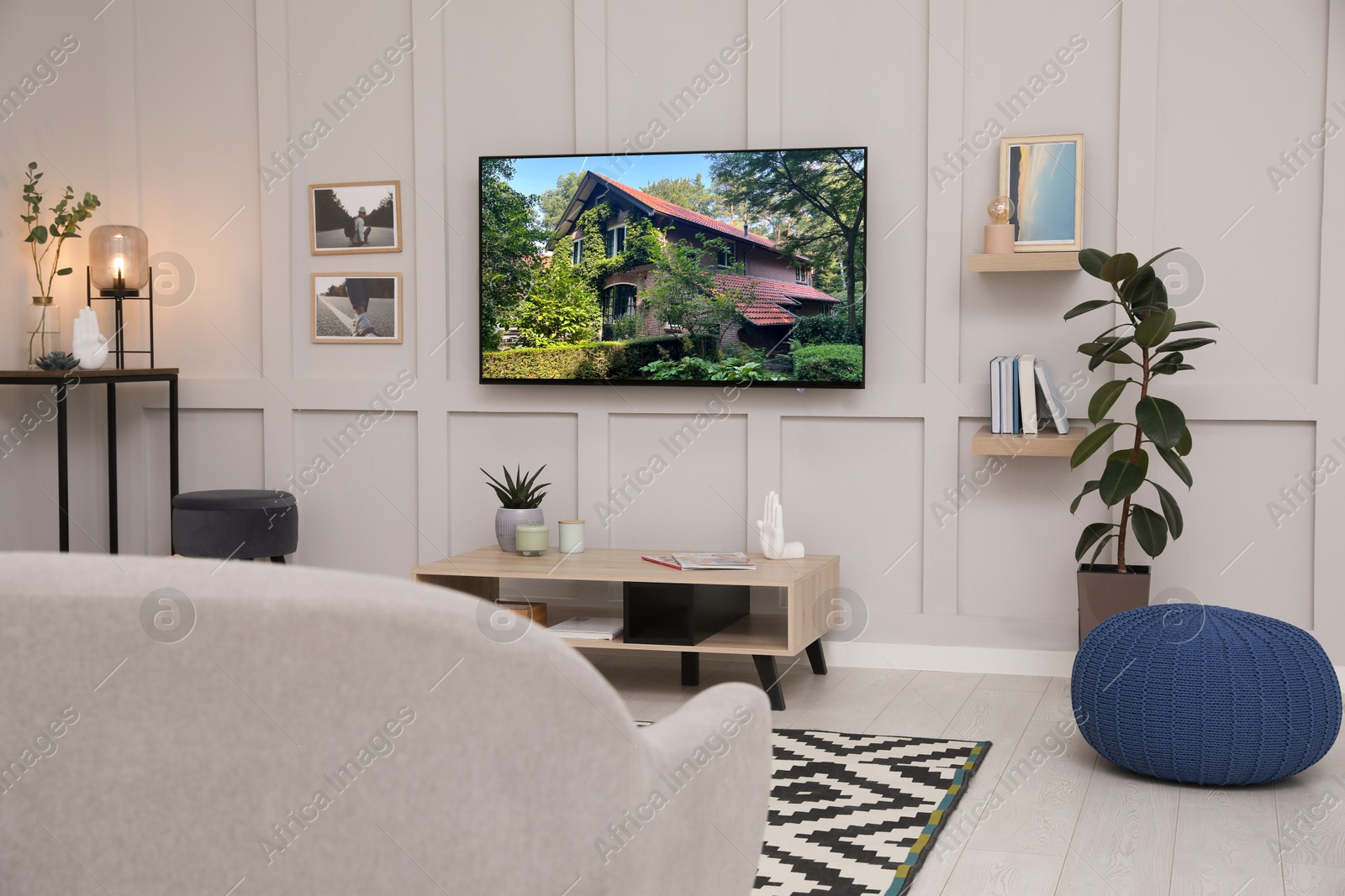 Image of TV set with beautiful house on screen in room