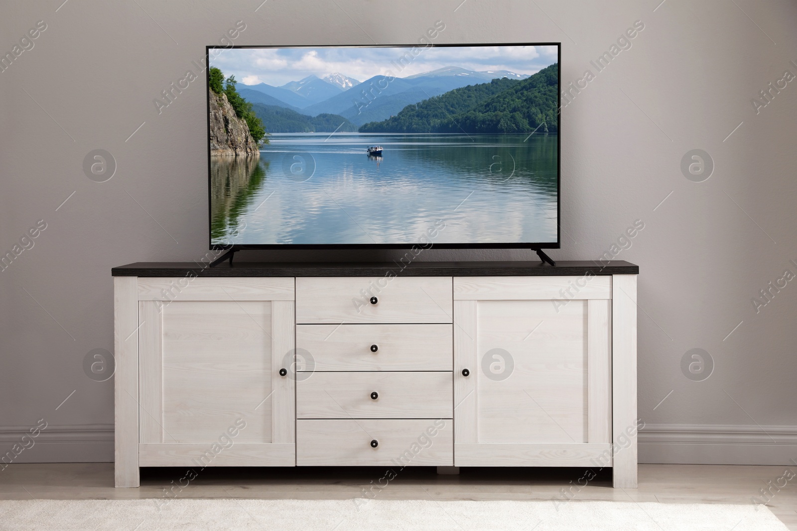 Image of TV set with nature landscape on screen in room