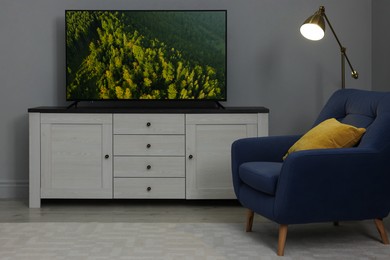 Image of TV set with mountain forest on screen in room