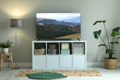 Image of TV set with nature landscape on screen in room