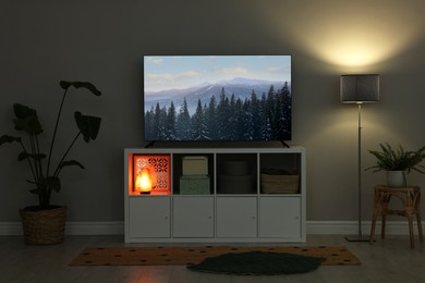 Image of TV set with nature landscape on screen in room