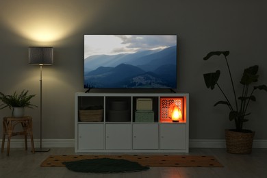 Image of TV set with nature landscape on screen in room