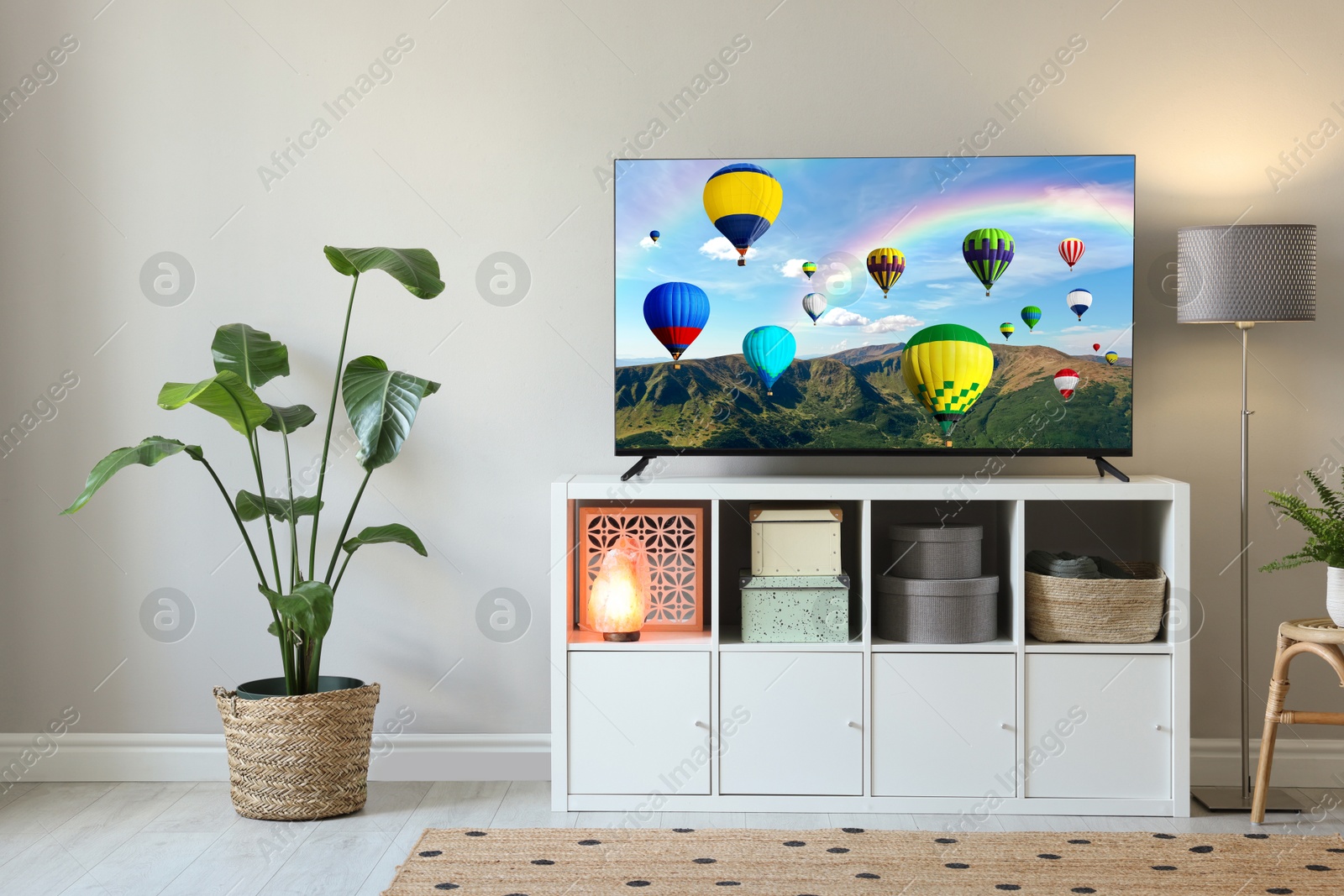 Image of TV set with hot air balloons floating over mountains on screen in room