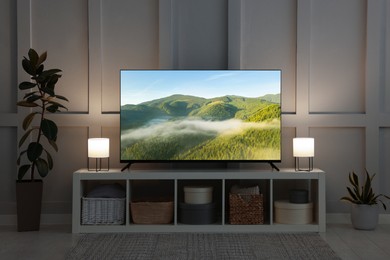 Image of TV set with mountain landscape on screen in room