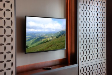 Image of TV set with mountain landscape on screen in room