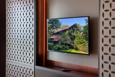 Image of TV set with beautiful house on screen in room