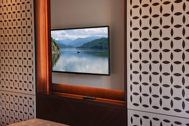 Image of TV set with nature landscape on screen in room