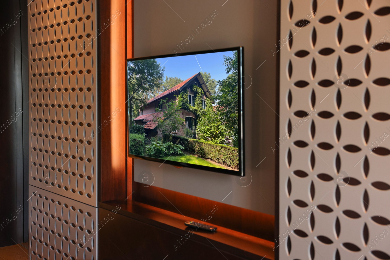 Image of TV set with beautiful house on screen in room